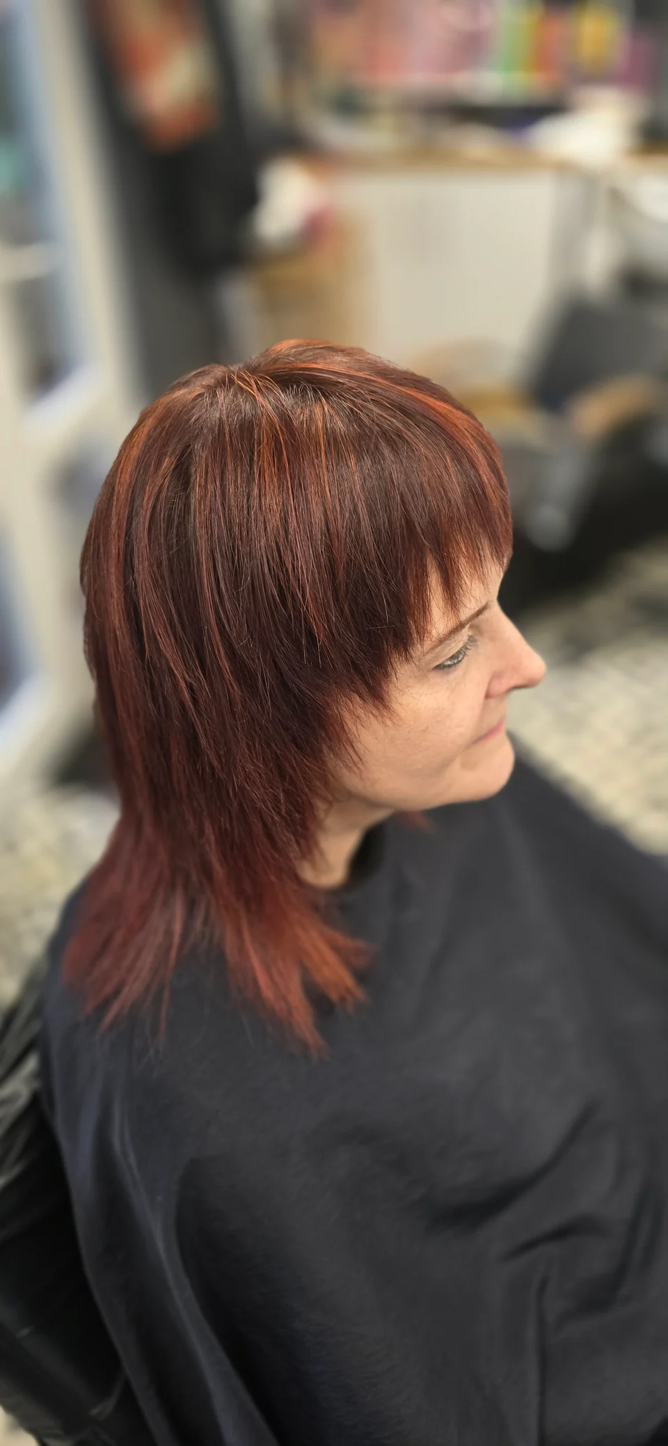 Layered auburn hair with a fringe, viewed from the side