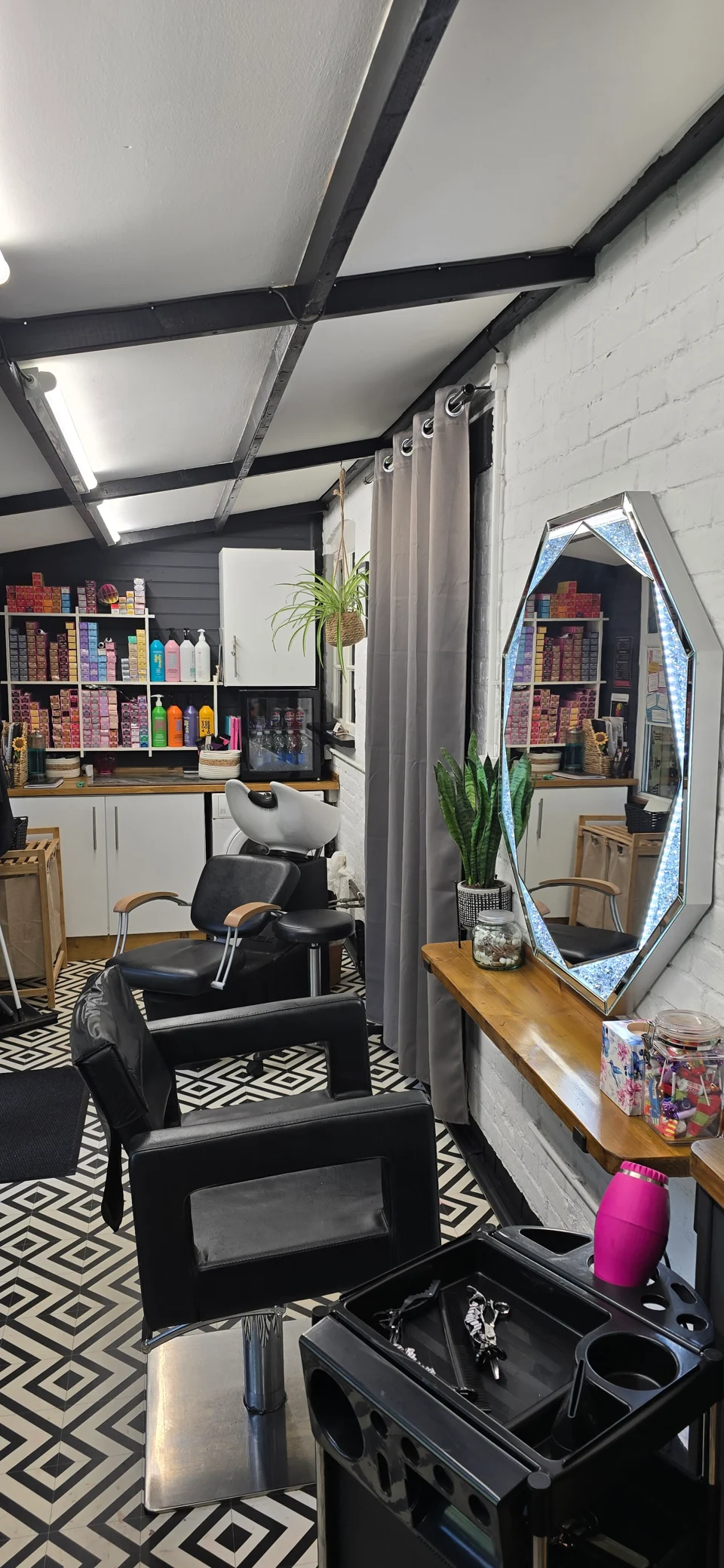 Salon styling station with a mirror, chair and professional hair products